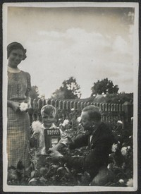 Lata 30. XX w. Fotografia kobiety i mężczyzny z dzieckiem w ogrodzie.